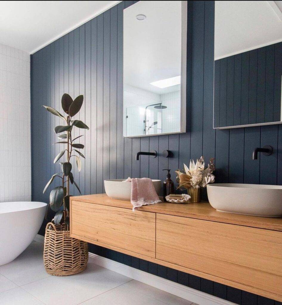 Modern bathroom with dual sinks, wooden vanity, and stylish decor in Sutherland Shire home renovation.